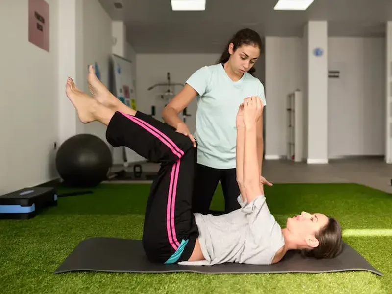 Dr. Moy guiding a patient through a balance and gaze stabilization exercise at Amplify Physical Therapy and Wellness in Bolingbrook