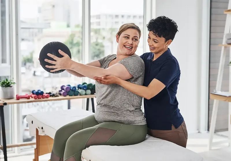 Physical therapist guiding a patient through a hands-on treatment session